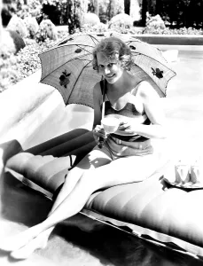 Bathing Suit Prints: Minna Gombell, sipping a cup of tea poolside, 1931