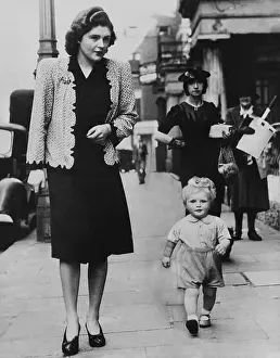 Grandson Prints: Mrs. Randolph Churchill (left) walking on a London street with her 20-month old son