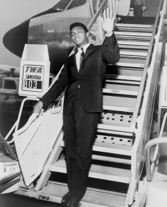 Heavyweights Prints: Muhammad Ali, waves from the steps of a TWA airplane at JFK International Airport in New York
