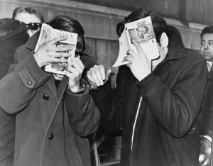 Narcotics Prints: Two New York City students covering their faces with books at police headquarters after they were picked up