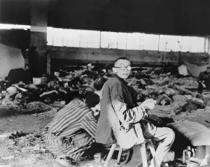 Austria Prints: Nordhausen Concentration camp prisoners having a meager meal among the dead