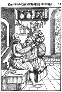 Patients Prints: Patient having a cataract removed from his left eye by a surgeon whose assistant immobilizing the patient