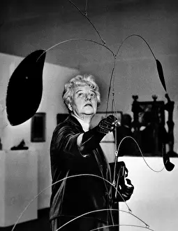 Images Dated 25th March 2007: Peggy Guggenheim adjusts Alexander Calder's Mobile at a special exhibit of her famed collection of art at the Tate