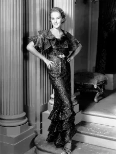 Lace Dress Prints: Phyllis Brooks, modeling a brown lace dress with gold embroidery, 1935