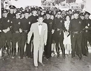 Excitement Prints: A police line protects Frank Sinatra from a crowd of young fans on his arrival at the Pasadena