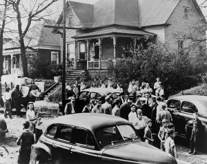 Housing Prints: Police and White citizens gather in the street as an African American family moves