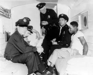 Ambulance Prints: Policemen and wounded African American man inside police ambulance