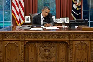 President Barack Obama at his Oval Office desk, Sept. 7, 2011. Obama is talking with Gov. Rick Perry about the unprecedented fires in Texas. (BSLOC_2015_3_2)