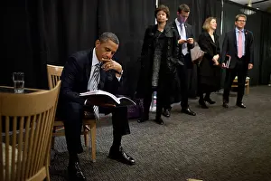 Denver Prints: President Barack Obama reviews notes as his staff waits before an event in Denver