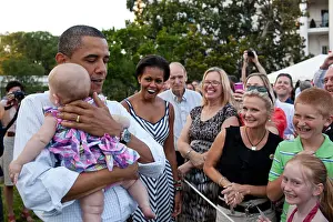 President Barack Obama soothes a crying baby at the Congressional Picnic