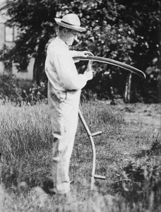 President Calvin Coolidge (1872-33) sharpening a scythe on his farm in Vermont