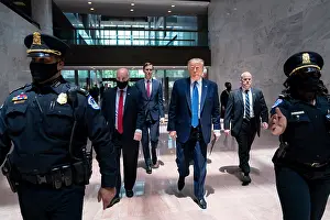 News Prints: President Donald Trump is escorted by Capital police as he arrives with staff for a Senate Republican election policy