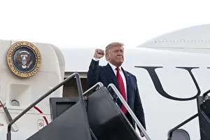 Salute Prints: President Donald Trump gives a clenched fist salute from Air Force One