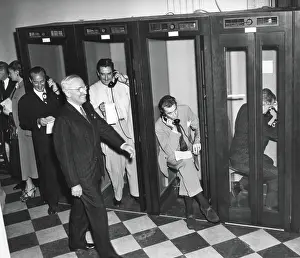 News Prints: President Harry Truman walks past reporters in the telephone booths the Old State Department Building