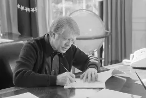 Cardigan Prints: President Jimmy Carter working at his desk in the White House Oval Office. Ca. 1977-1980
