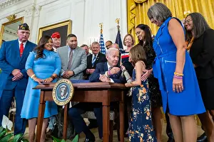 Robinson Prints: President Joe Biden hands the pen to Brielle Robinson after signing the Sergeant First-Class Heath Robinson Honoring