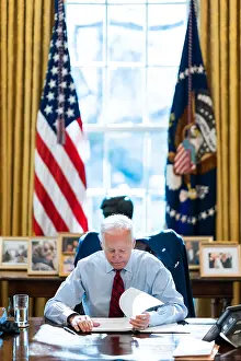 Elderly Adult Prints: President Joe Biden reading documents at his desk in the White House Oval Office