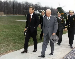 Cuba Prints: President Kennedy and former President Eisenhower walk ahead of military aides at Camp David