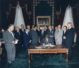 President Kennedy signing the Nuclear Test Ban Treaty which banned nuclear tests in the atmosphere, underwater and in space