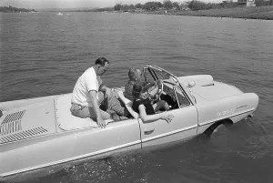 President Lyndon Johnson taking guests for a cruise in his Amphicar
