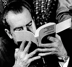 President Richard Nixon takes a close look at his economic report to Congress during the signing ceremony at the White House. Feb. 1, 1974