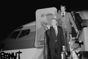 Political Campaigns Prints: Presidential candidate Jimmy Carter carrying his own luggage as he disembarks from the airplane Peanut One