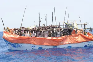 Piracy Prints: Primitive boat crowded with suspected pirates under arrest and awaiting a U