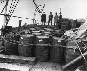 Boats Prints: Prohibition agents examining barrels on the captured rum-runner, Tomoka, in Nov. 1924