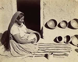 1870s Prints: A Pueblo Indian woman polishes a pottery bowl in a doorway