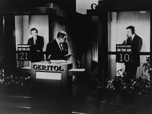 Broadcast Prints: Quiz show 21 host Jack Barry addresses contestant Hank Bloomgarden as fellow contestant James Snodgrass looks