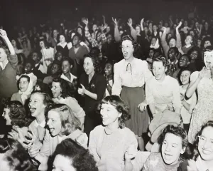 Excitement Prints: Racially integrated audience listens as singer Frank Sinatra speaks against racial prejudice in Gary