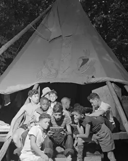 Sharing Prints: Racially integrated group of boys sharing a comic book at Camp Nathan Hale in Southfields