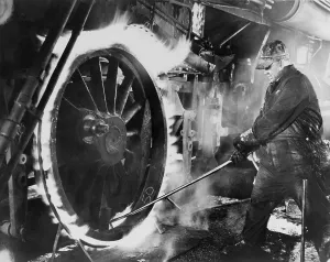Sweating Prints: Railroad worker sweating a tire on a locomotive wheel