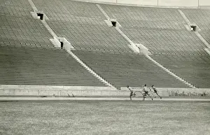 Lcgr1805 Prints: Relay racers practice baton handoff in an empty stadium