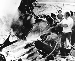 Automobiles Prints: Rescuers gather around Peter Revson's wrecked race car at a Johannesburg race track