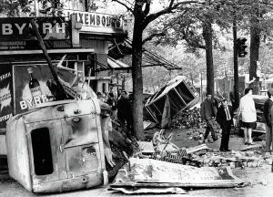 Riots Prints: RIOTS-Parisians inspect overturned auto and other debris in the Edmond Rostand Square after riot