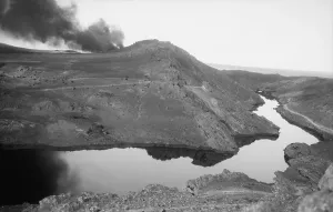 Wells Prints: A river of crude oil flowing through the Iraq desert resulting from a gusher Kirkuk District of Iraq