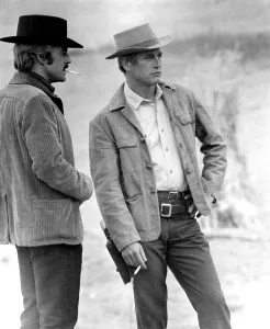 Robert Redford, Paul Newman smoking cigarettes between takes on BUTCH CASSIDY AND THE SUNDANCE KID, 1969. TM and Copyright (c) 20th Century Fox Film Corp. All rights reserved