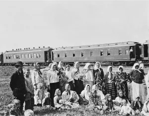 Peasants Prints: Russian men, women, and children in traditional dress posing in near a passenger train in a Siberian field