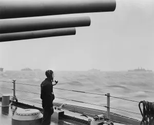 Atlantic Ocean Prints: A sailor on a warship keeps alert watch over merchant ships in a convoy