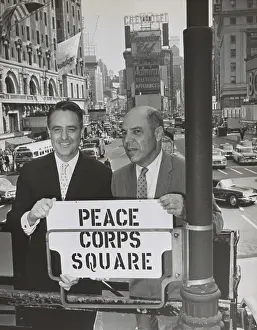 Publicity Prints: Sargent Shriver and Edward R. Dudley in Times Square with a sign Peace Corps Square