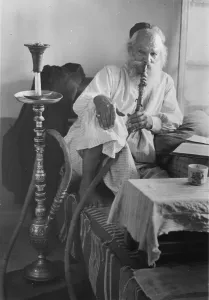 Images Dated 9th July 2008: Seated man smoking a nargile, or water pipe, photograph, 1898-1946