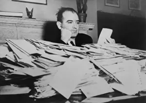 Publicity Prints: Sen. Joseph R. McCarthy sits at desk piled high with mail