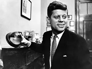 Office Prints: Senator John F. Kennedy, holds a mounted half of a cocoanut in his Senate office