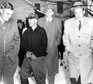 September Prints: Serial Killer Ed Gein is led away from his farm by detectives