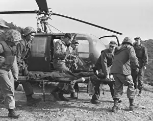 Teamwork Prints: A seriously wounded U.S. Marine is rushed to helicopter by the Corpsmen