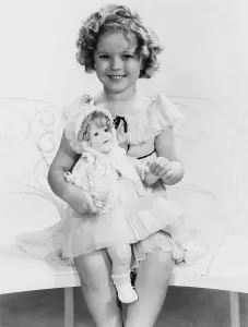 Temple Prints: Shirley Temple, with a Shirley Temple doll, ca. 1935