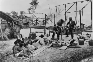 War Victims Prints: South Vietnamese woman and children sit amid ruins of their village