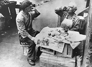 Beards Prints: Two street vendors have lunch at a makeshift table of wooden crates covered with newspaper
