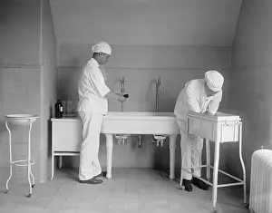 Doctors Prints: Surgeon and anesthesiologist carefully wash their hands and lower arms in specialized sinks